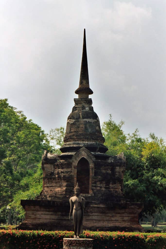 Buddha statue in front of ancient stupa in Sukhothai