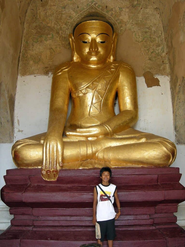 guide proudly posing in front of Buddha statue
